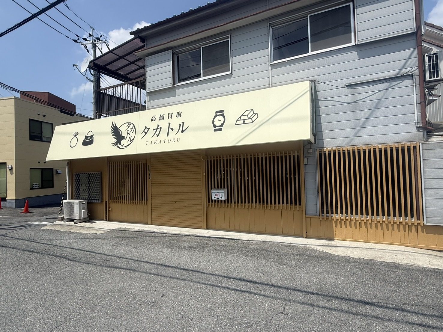 高価買取タカトル 店舗外観（クリーム色の看板とウッド調シャッターが目印）